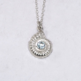 Small silver ammonite pendant with light blue topaz